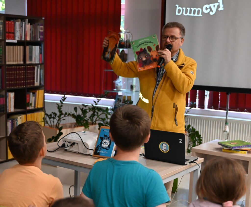 Marcin Kozioł pokazuje swoje książki uczniom.