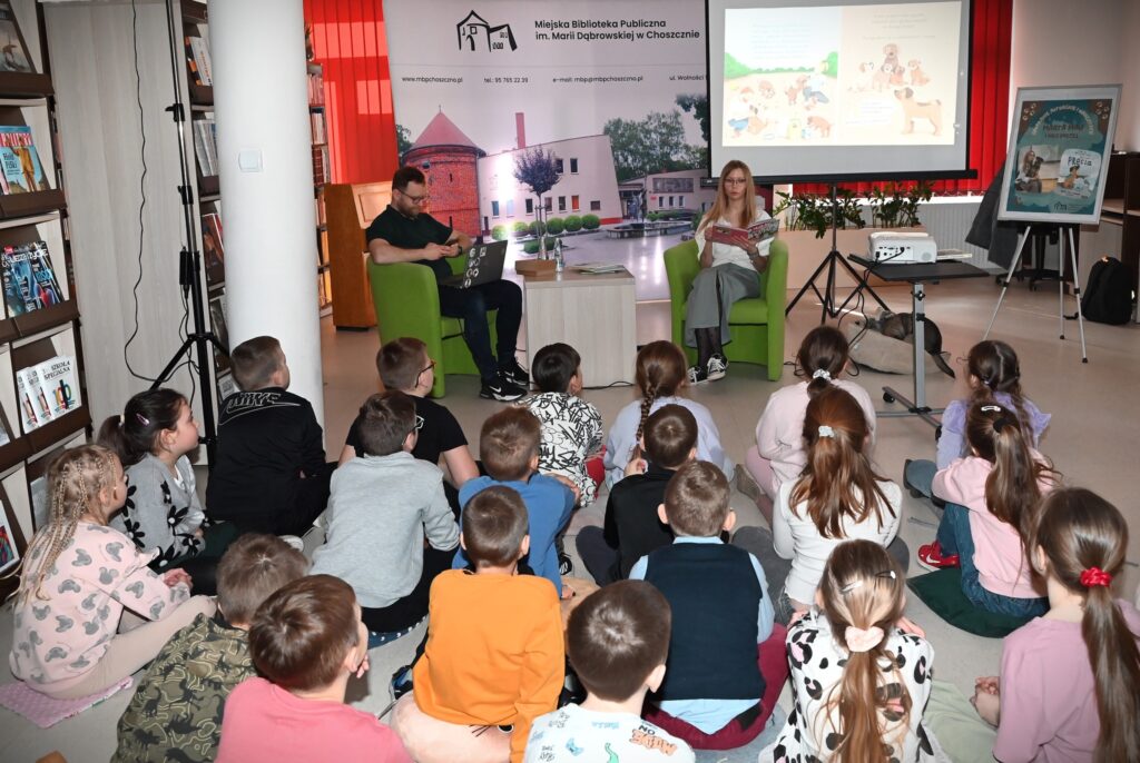 W fotelach siedzą przed dziećmi prelegenci.