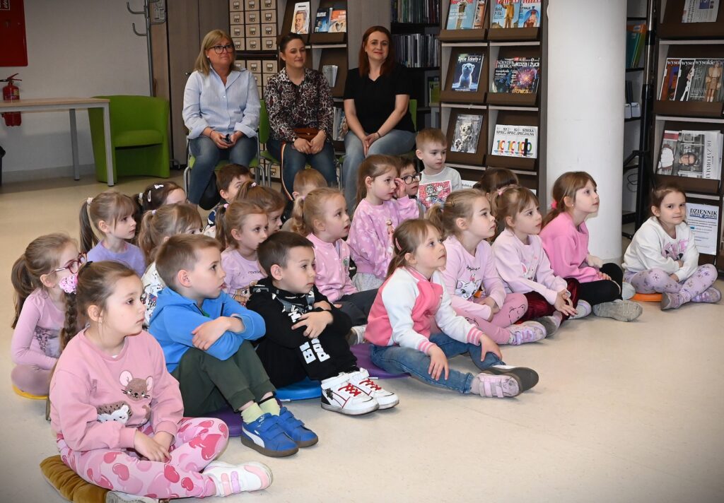 Siedzące na poduszkach dzieci.