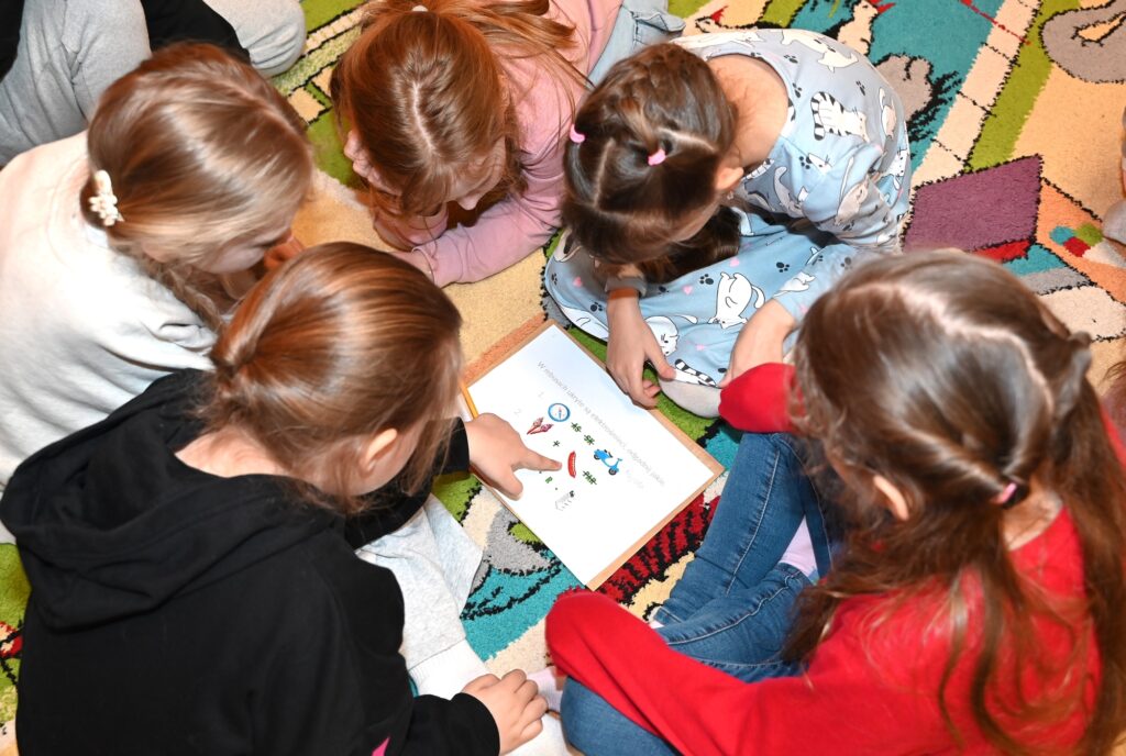 Dzieci pracują w grupie, rozwiązując rebus.