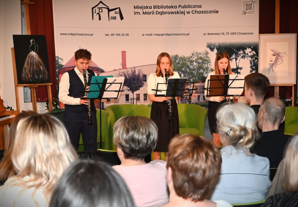 Troje młodych wykonawców gra na instrumentach.
