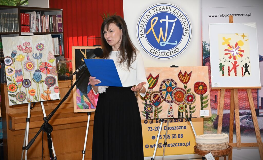Katarzyna Jezierska. Za nią stoją obrazy.