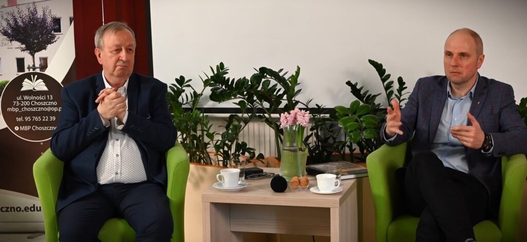 Od lewej siedzą: Joachim Jan Zdrenka i Marceli Tureczek. Miedzy nimi stoi stolik.