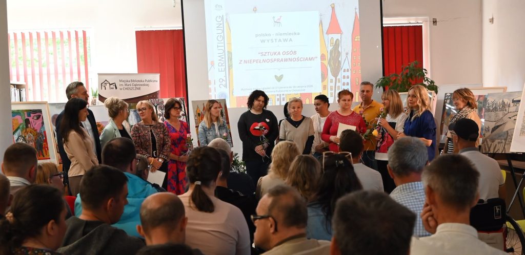 Pracownicy warsztatów, podopieczni , wiceburmistrz, goście z Niemiec stoją przed publicznością.
