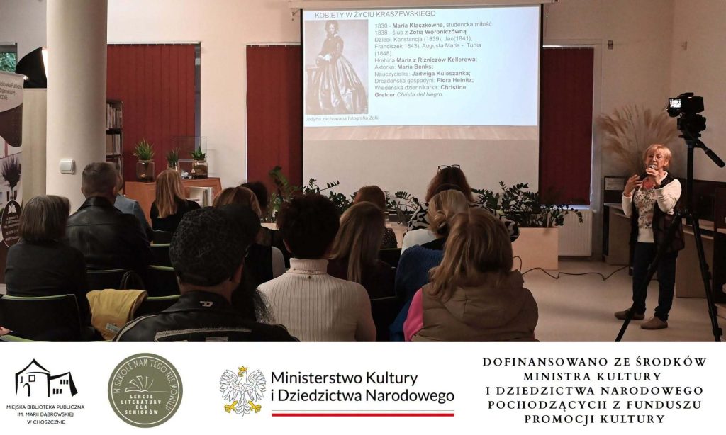 Cecylia Judek przed publicznością. Za nią na ekranie slajd "Kobiety w życiu Kraszewskiego".