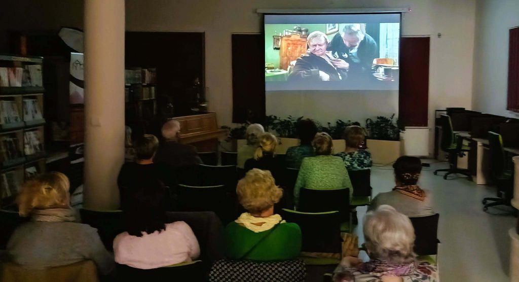 Publiczność ogląda film. Na ekranie Rzecki i doktor.